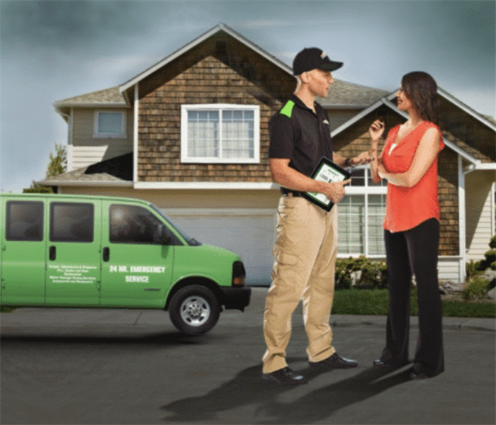 SERVPRO vehicle and house with customer and technician